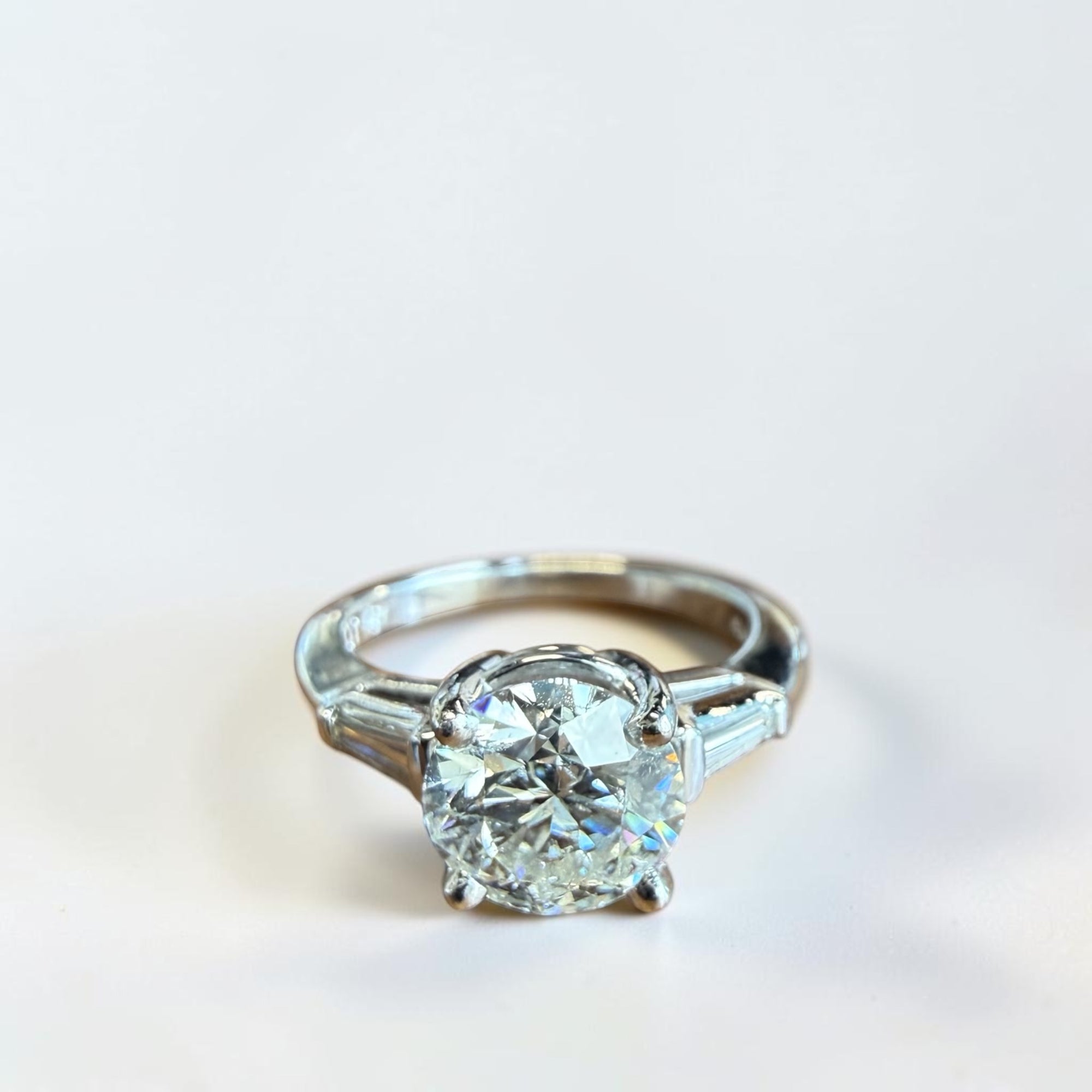 Platinum three stone diamond ring with 2.21 carat round brilliant center diamond and tapered baguette side stones, Cherry Pick Diamonds St. Louis