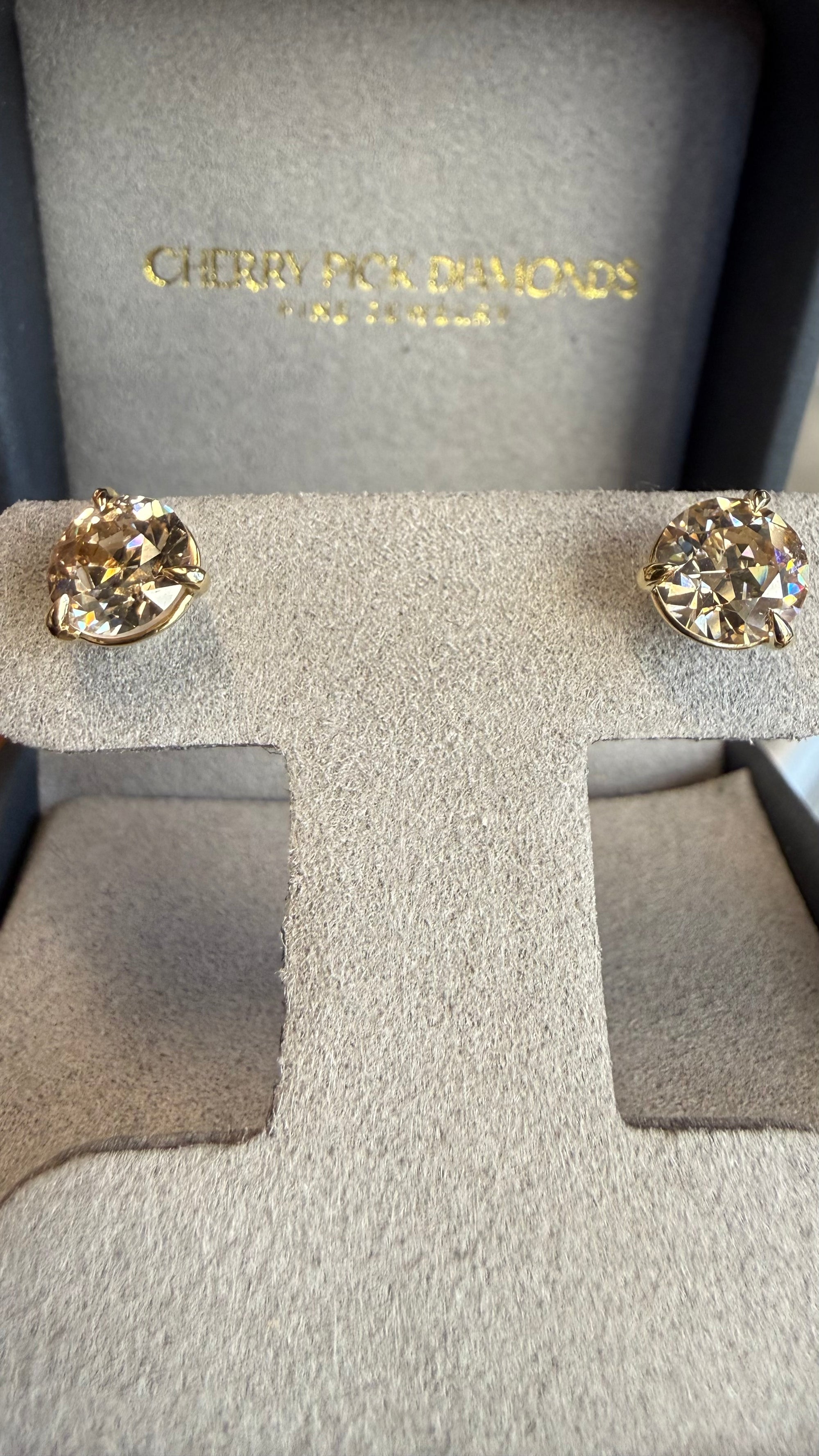 Side view of champagne diamond stud earrings in martini setting, Cherry Pick Diamonds Ladue Frontenac
