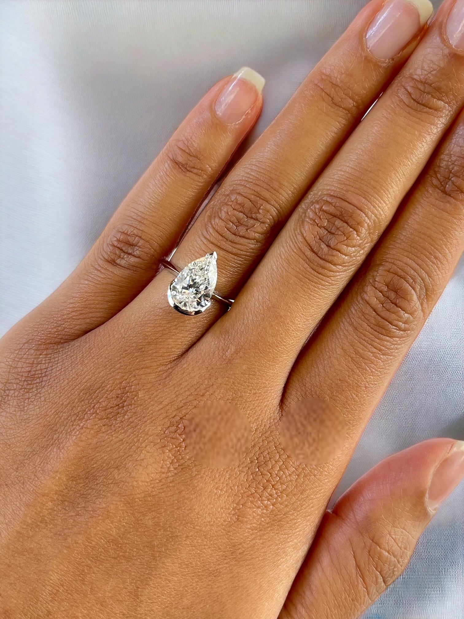 Monaco white gold pear shape diamond bezel ring close-up – Cherry Pick Diamonds Clayton MO