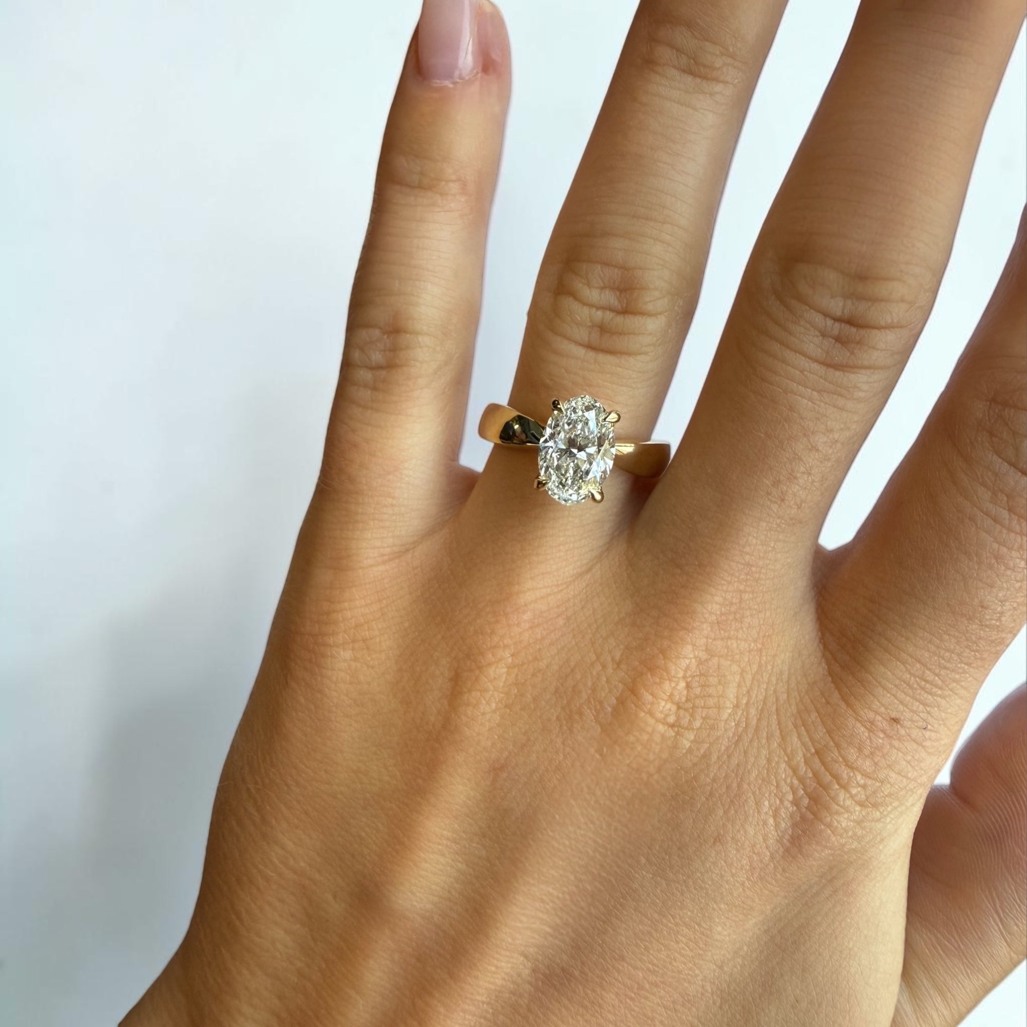 Close-up of 2.06ct F color oval brilliant natural diamond in yellow gold hidden halo setting — Cherry Pick Diamonds Clayton Missouri