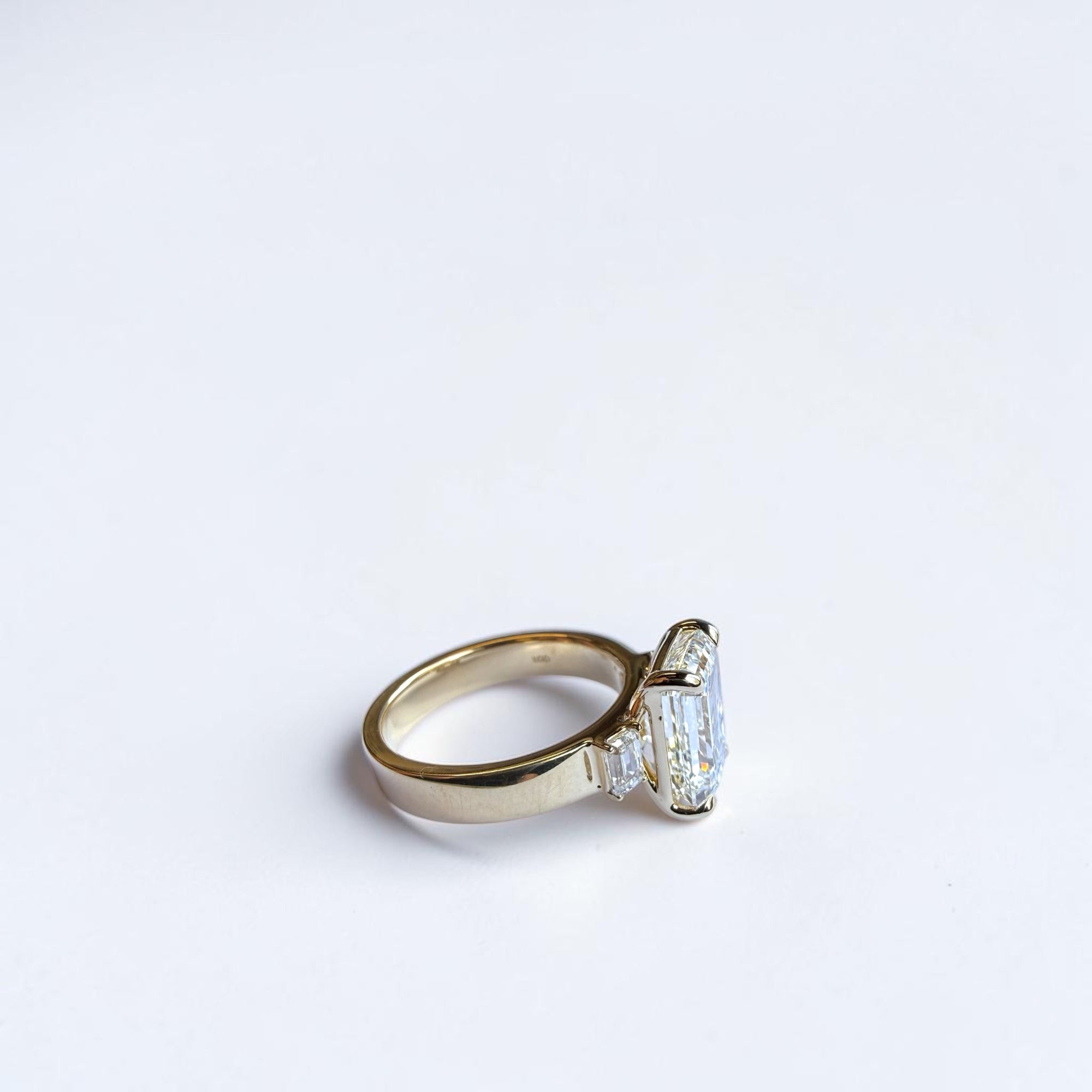 Close-up of emerald cut trio engagement ring with matching side diamonds, St. Louis fine jewelry